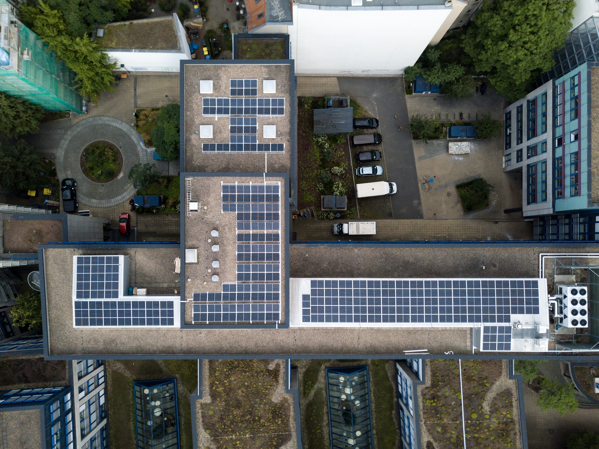 Imagen aérea de un edificio en la ciudad con instalación de paneles solares para autogeneración de energía